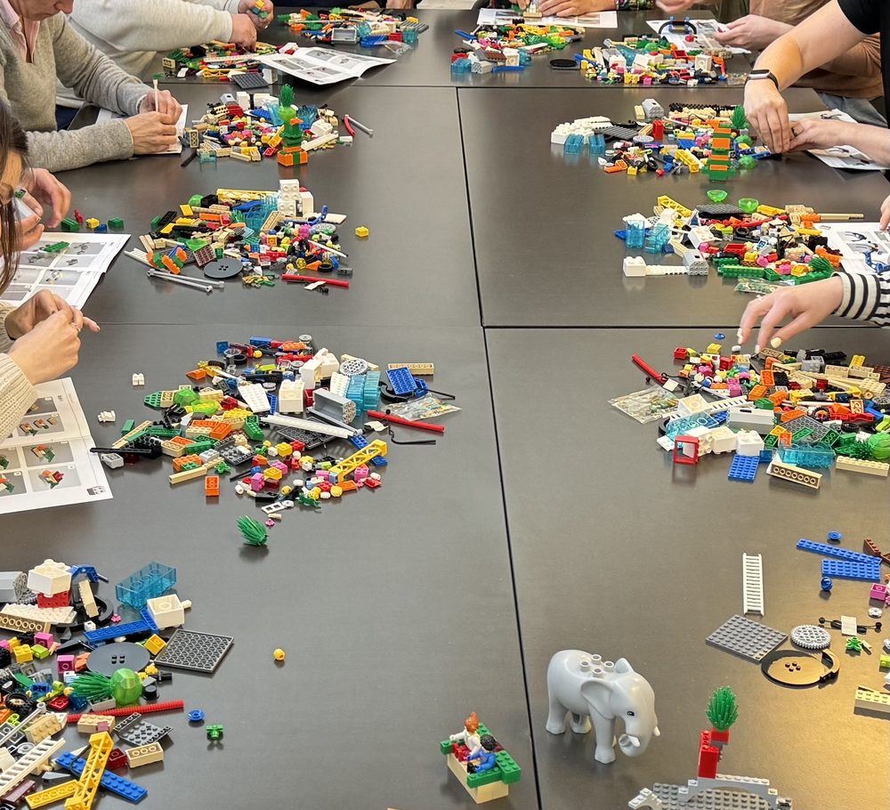 Participants construisant leurs modèles pendant une formation LEGO® SERIOUS PLAY®, chacun devant son kit de briques