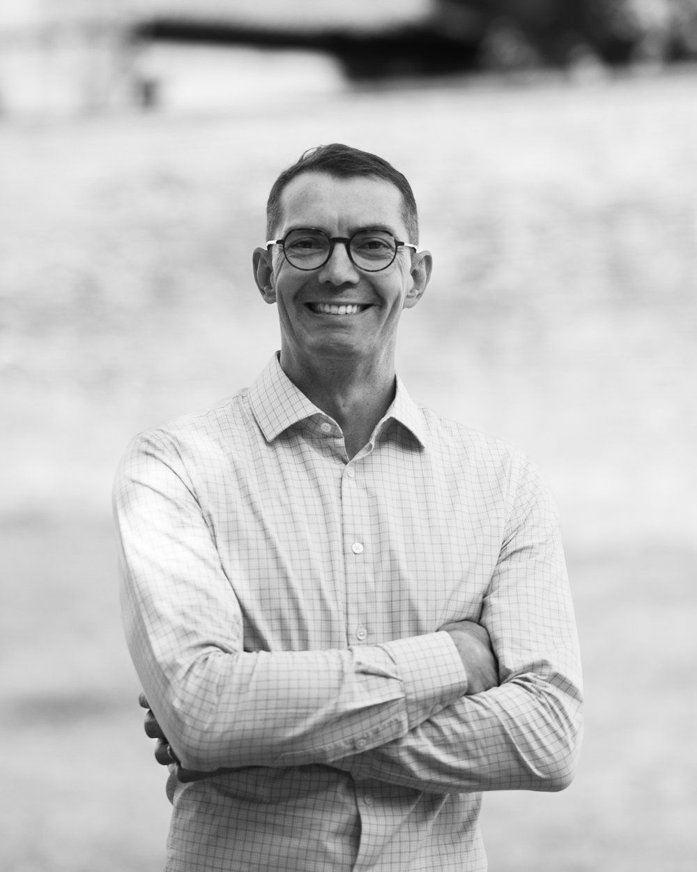 Portrait en noir et blanc de Cédric Berrest, bras croisés et souriant, coach et facilitateur LEGO® SERIOUS PLAY® à Toulouse