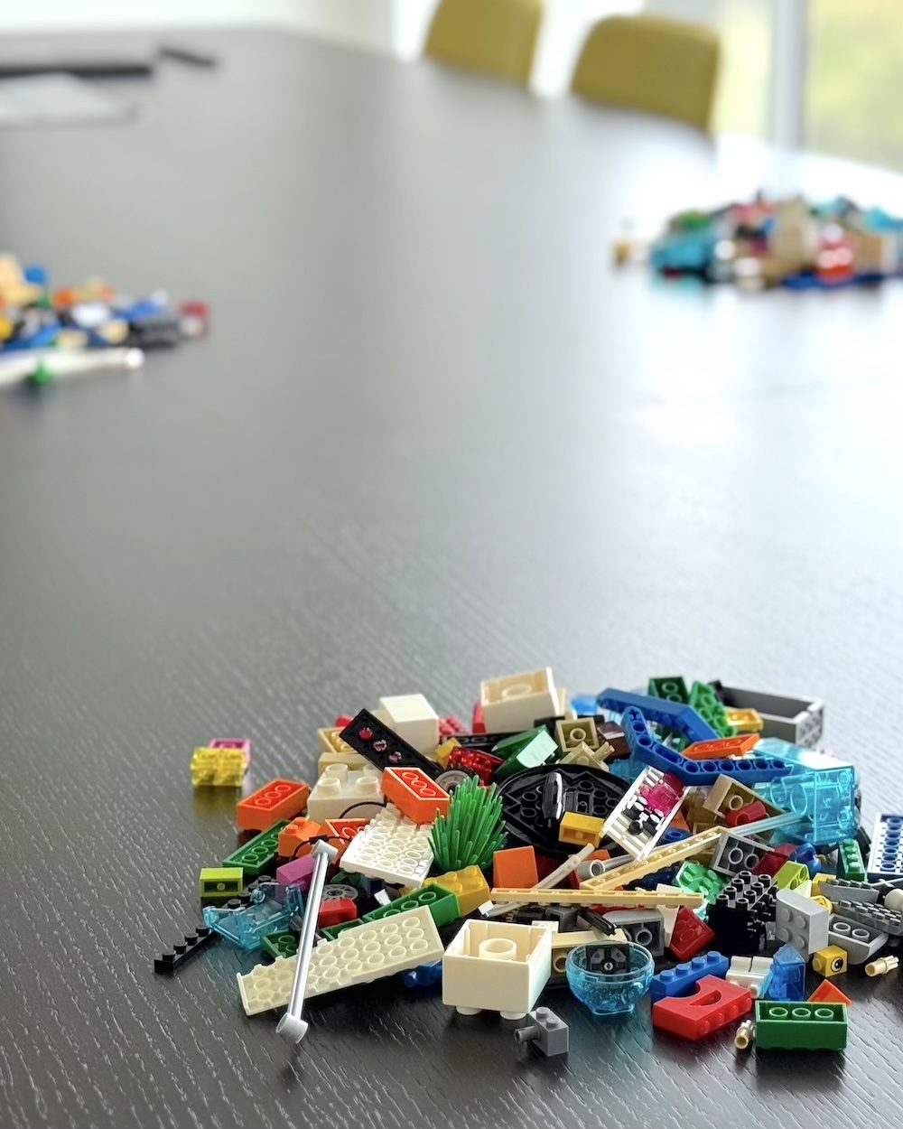 Sélection de briques disposée sur la table d'une salle de formation LEGO® SERIOUS PLAY®, avant l'arrivée des participants